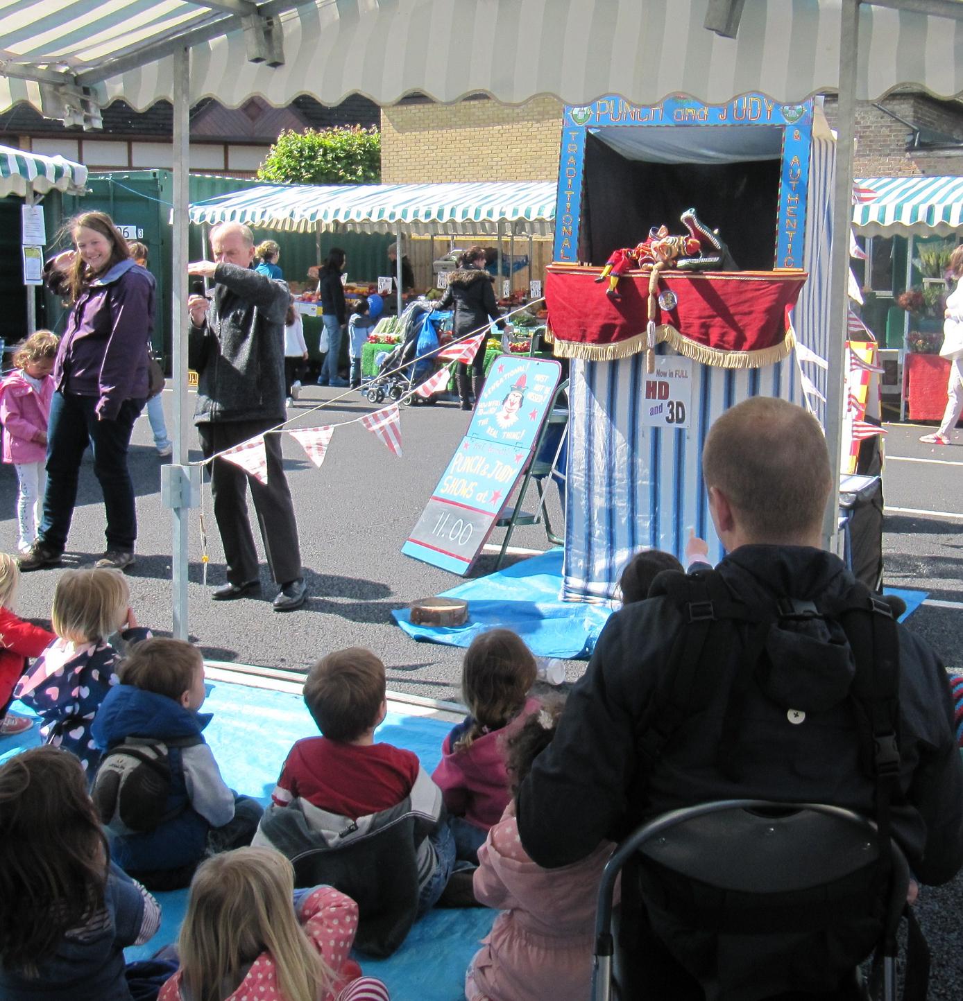 Punch and Judy show entertaining young children in Barnet Market