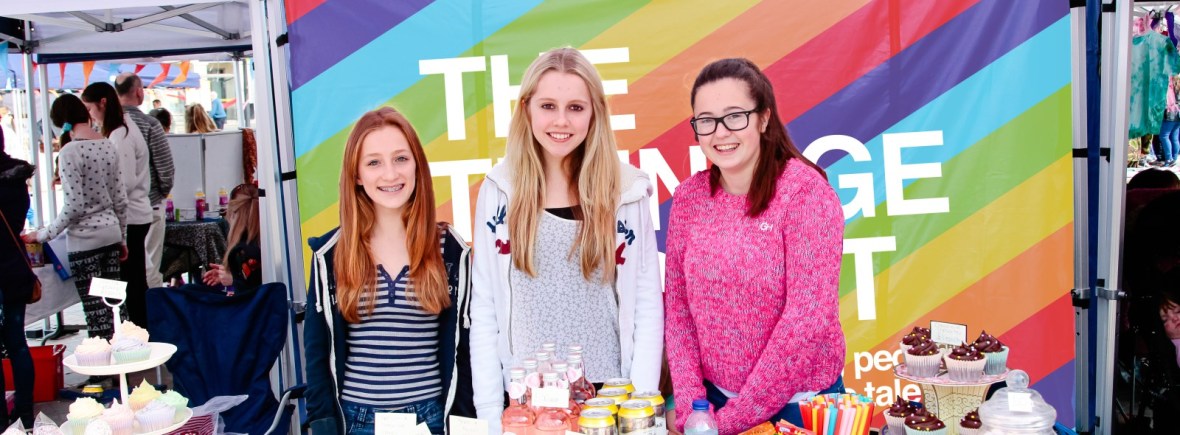 Three young stallholders standing behind their good at a Teenage Market